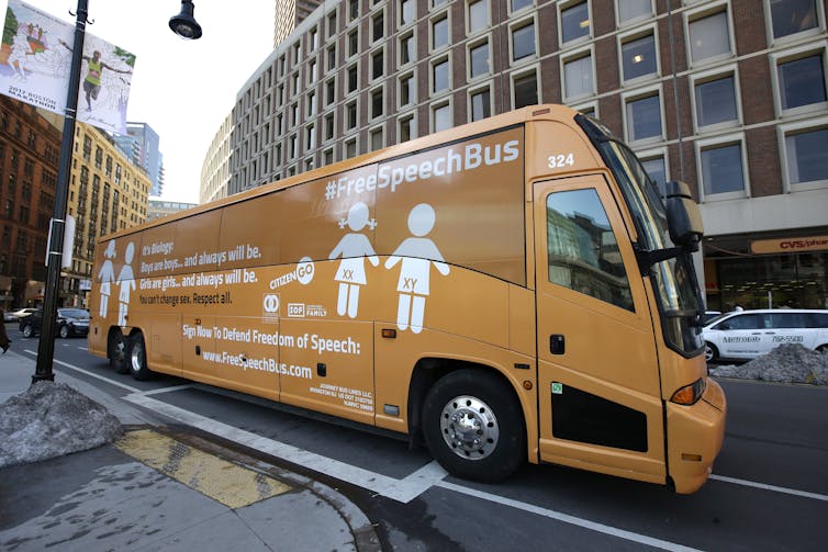 Un bus, peint avec les mots "les garçons sont des garçons" et "les filles sont des filles", est garé dans une rue de Boston.