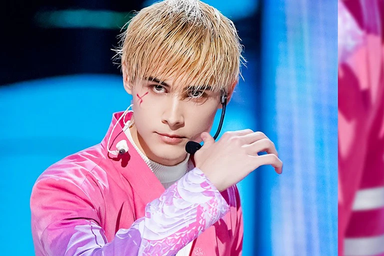 Boy band singer dressed in pink.