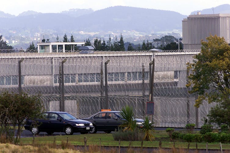 exterior of prison with high fence and concrete walls