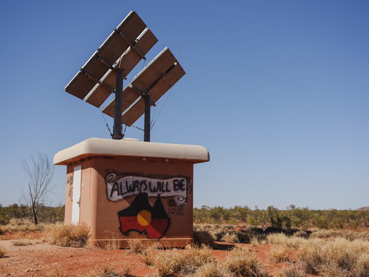 Satellite dish in Uluru with a painted Aboriginal flag saying