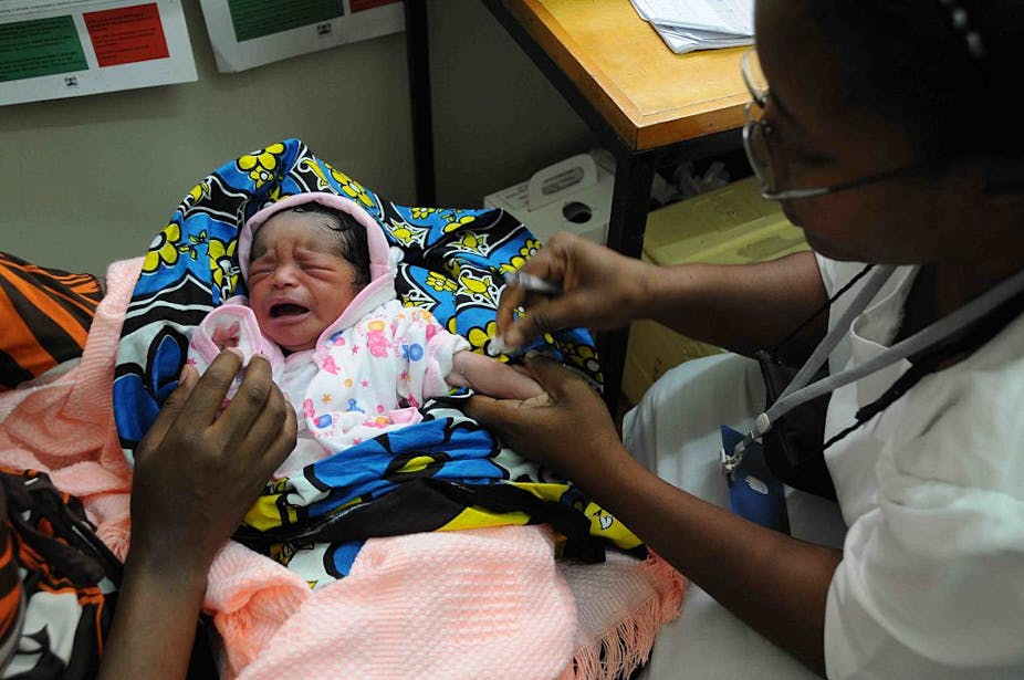 A community health worker attends to a baby