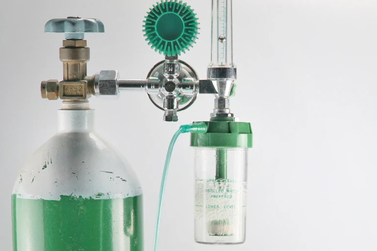 A cylinder of oxygen attached to a gauge, for hospital use.