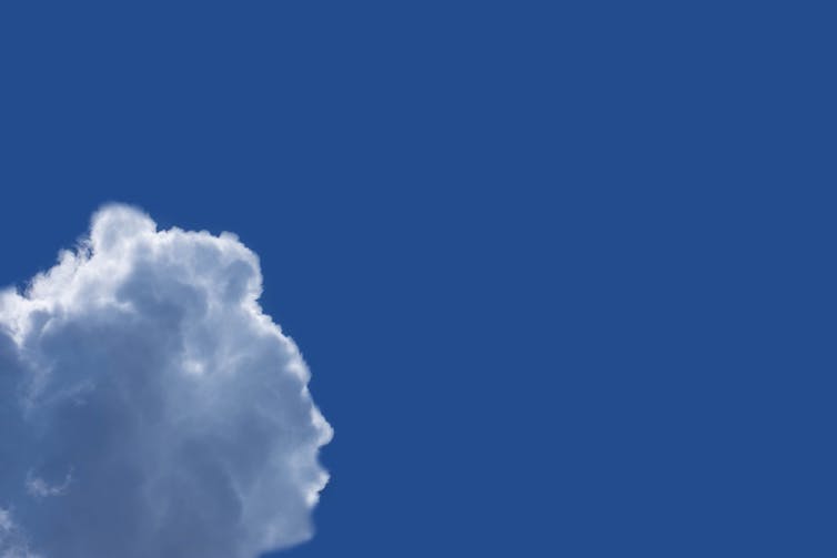A cloud shaped like the profile of a face in a blue sky
