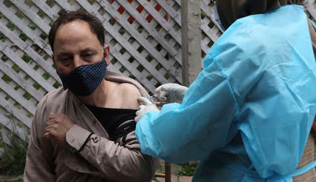 An Indian man being vaccinated for COVID-19