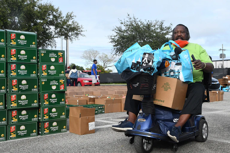 Man in motorized chair carries bags of food