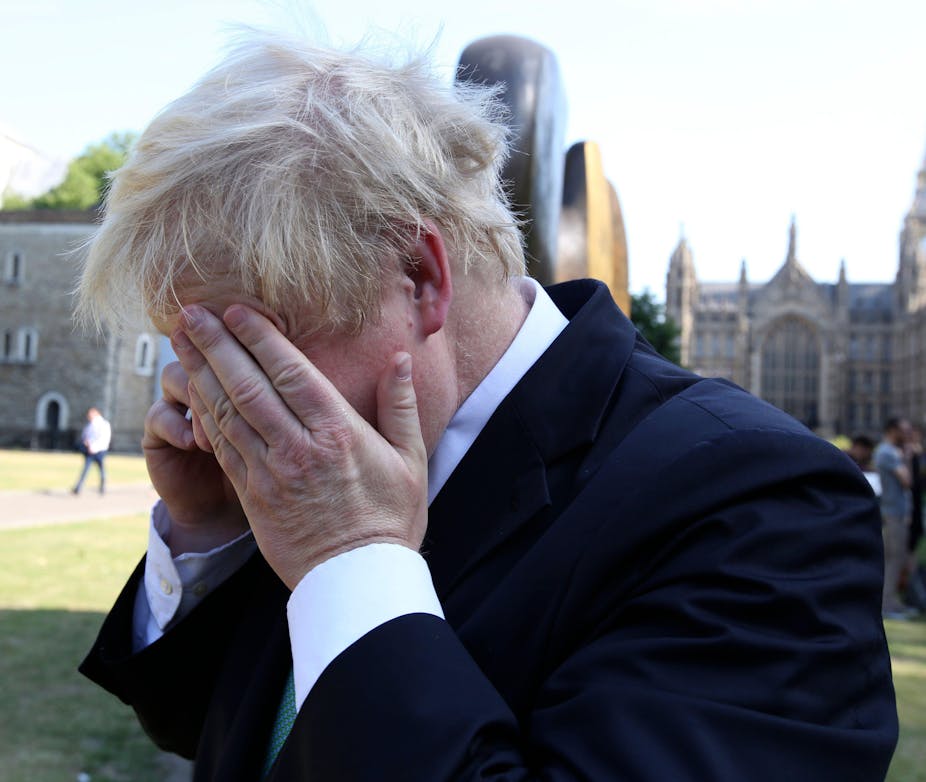 Boris Johnson rubs his eye while on the phone