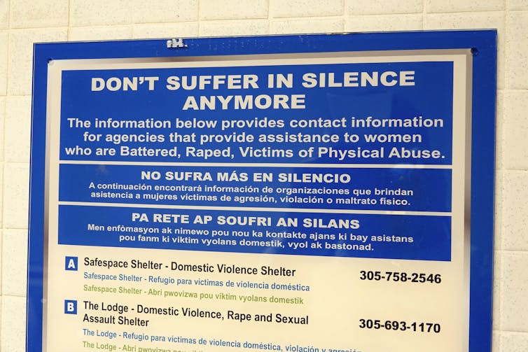 A sign on a wall that provides contact information to help victims of battering, rape and other physical abuse.