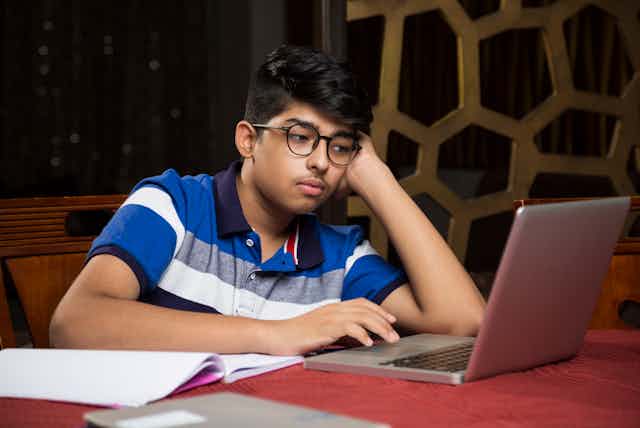 A bored students looks at his computer.