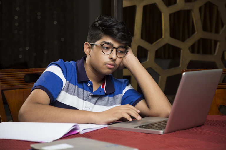 A bored students looks at his computer.