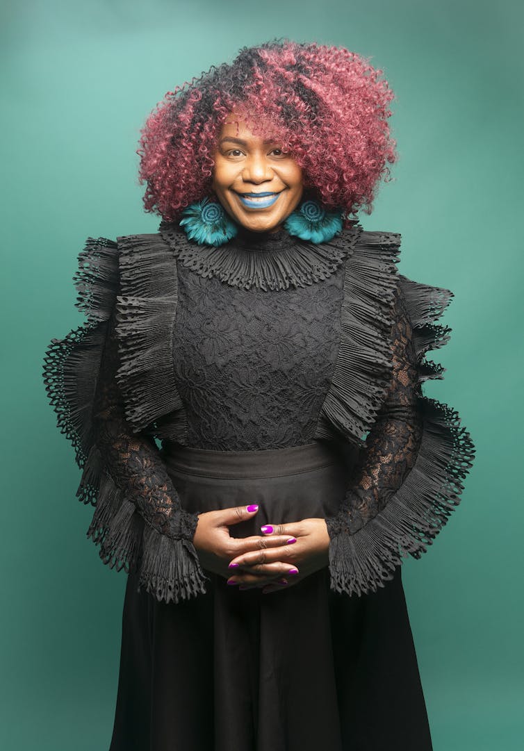 Woman with black dress, red hair, blue earrings