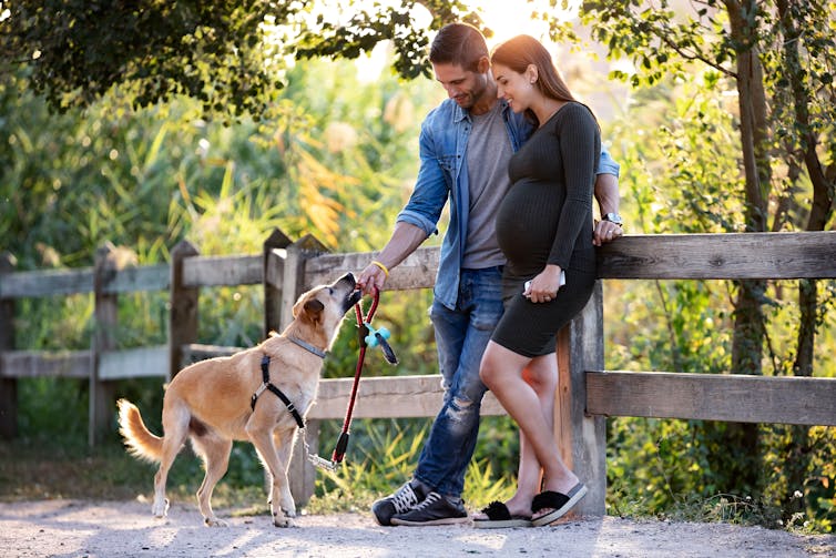 Un homme et une femme à l’extérieur, avec un chien