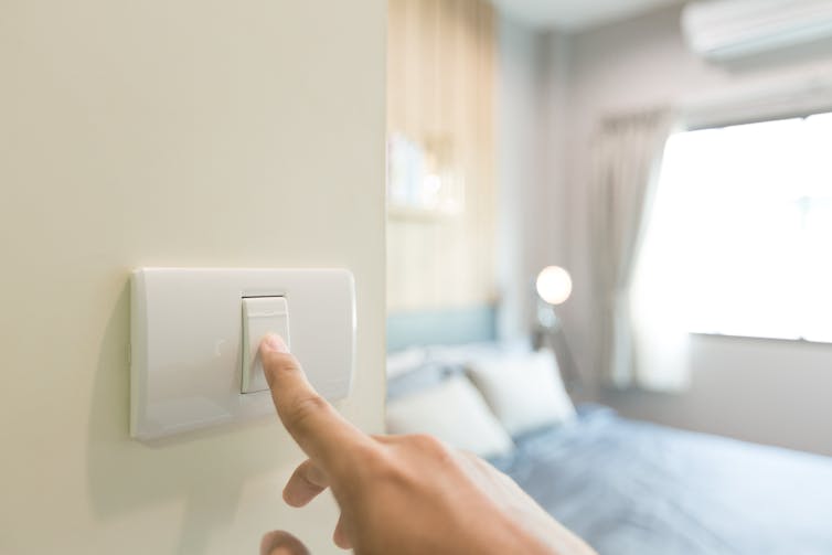 hand turns off light switch in bedroom