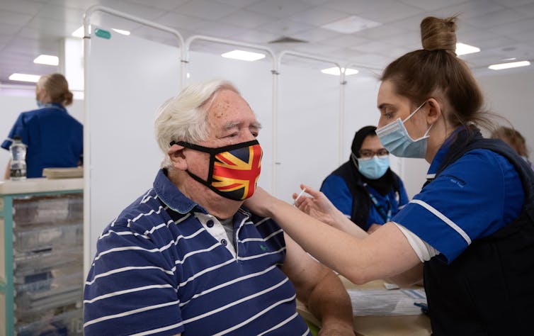 An 84 year old man receives a COVID-19 vaccine in Britain.