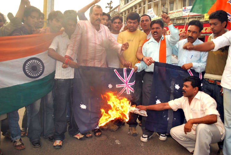 Protesters burn an Australian flag