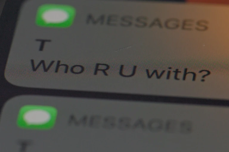 Text message saying 'Who R U with?'