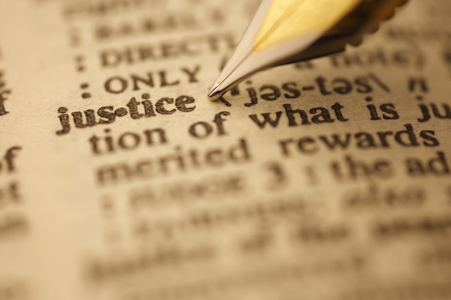 An ink pen pointing at the word 'justice'.