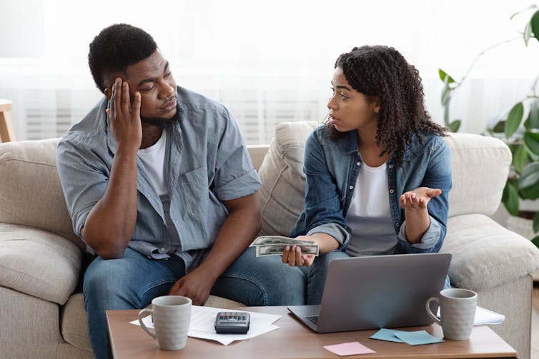 A concerned couple sitting on a couch