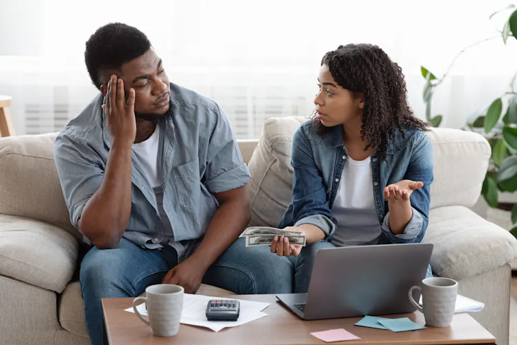 A concerned couple sitting on a couch