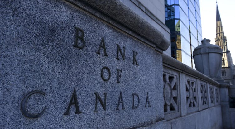 'The Bank of Canada' is etched onto a stone wall.