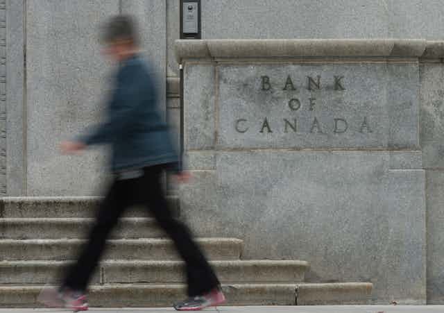 A woman walks past the Bank of Canada 