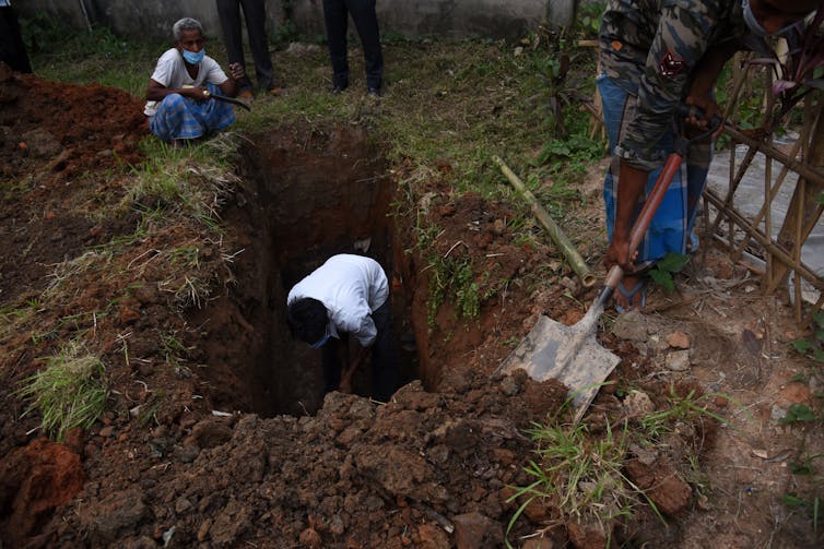 A worker digging a cemetery in Guwahati,  India.