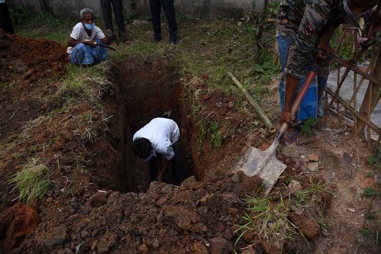 A worker digging a cemetery in Guwahati, India.