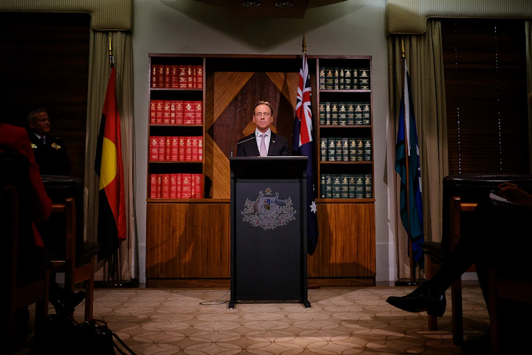 Health Minister Greg Hunt surrounded by the national flags at press conference.