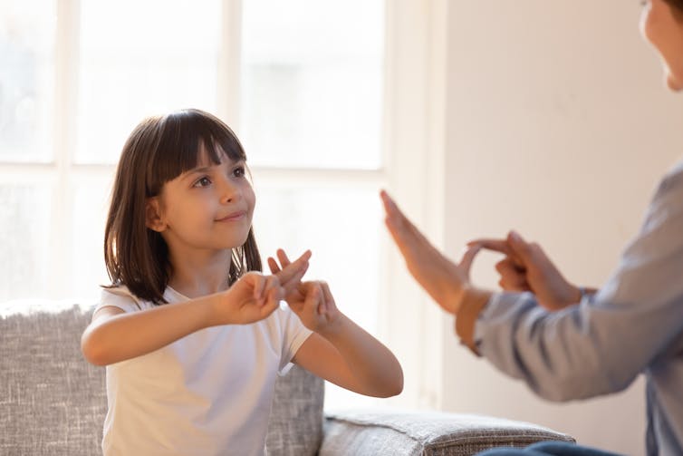 Girl and woman communicating via sign language.