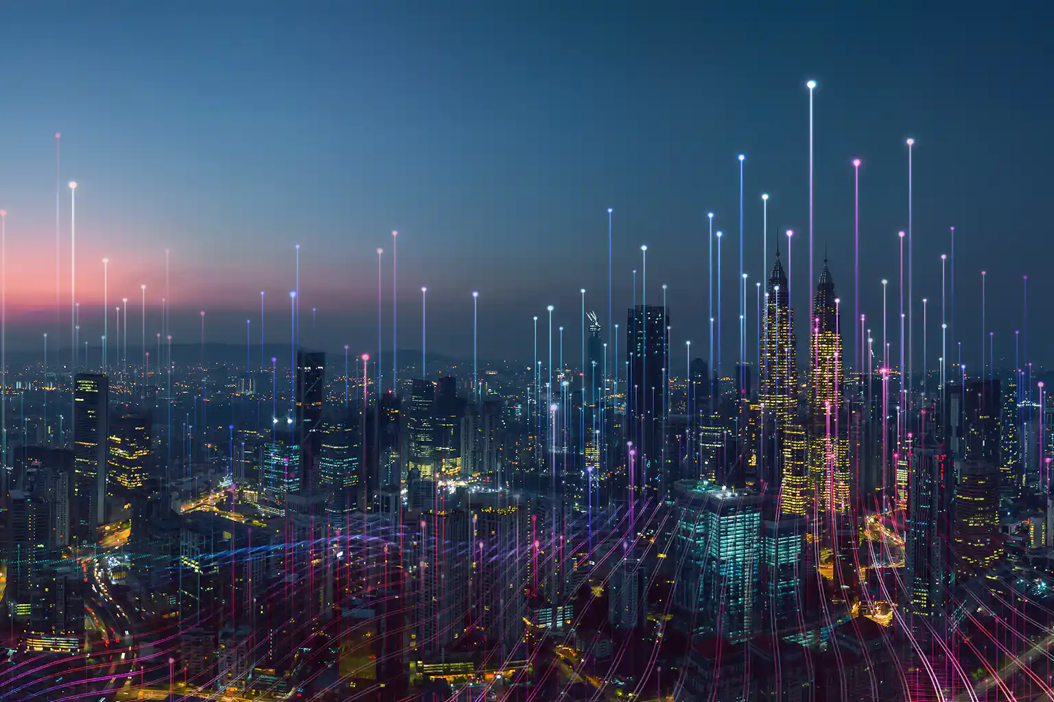 A photo of a city at night time with streaks of light coming out of each skyscraper.