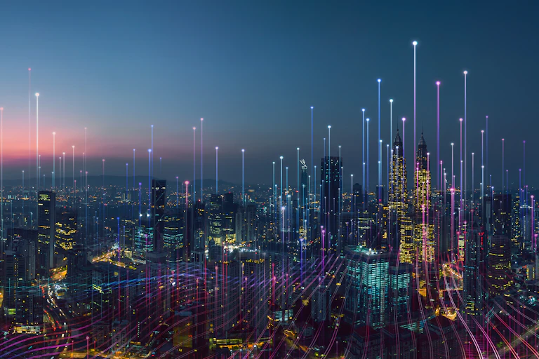 A photo of a city at night time with streaks of light coming out of each skyscraper.