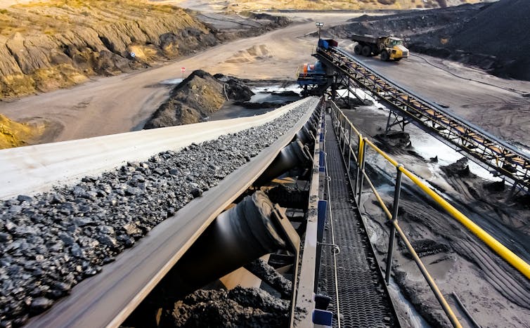 A conveyor belt carrying coal ore in an open-cast mine.