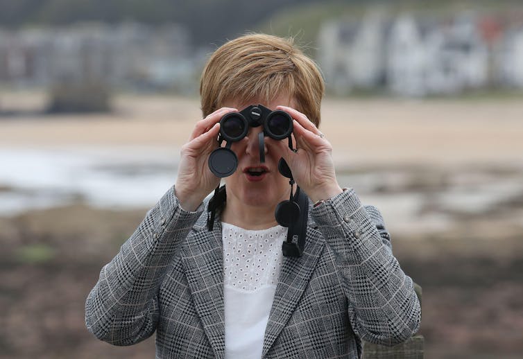Nicola Sturgeon looking through binoculars.