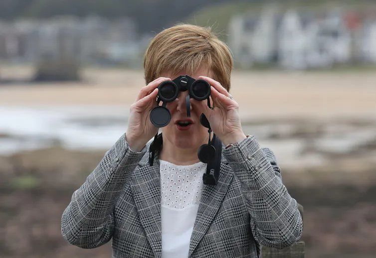 Nicola Sturgeon looking through binoculars.