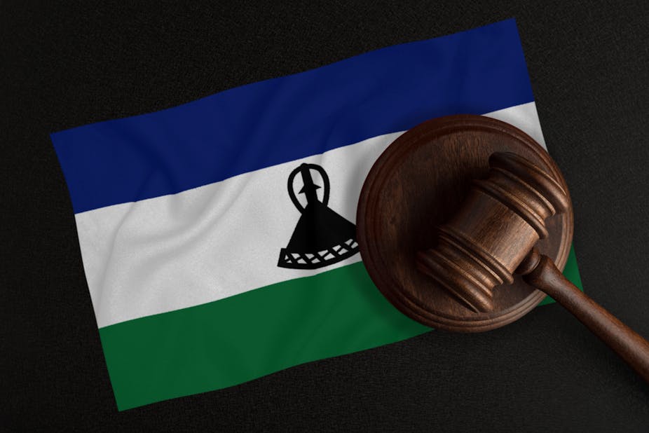 A judge's gavel is superimposed on a flag showing the Basotho traditional straw hat that is the country's national symbol.