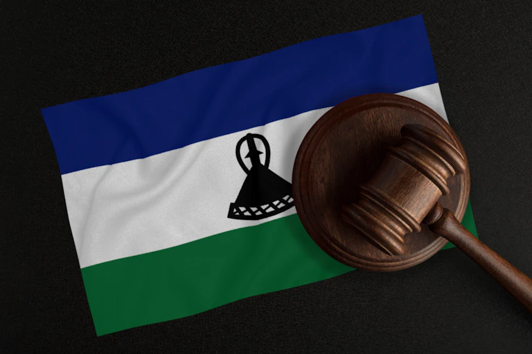 A judge's gavel is superimposed on a flag showing the Basotho traditional straw hat that is the country's national symbol.