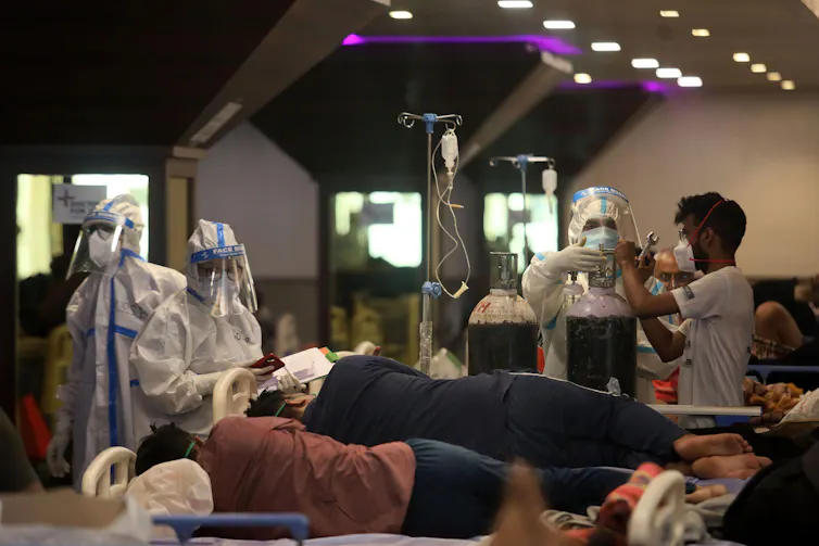 Medics in PPE attend to COVID-19 patients in a makeshift ward in India.