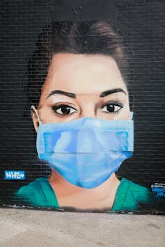 Mural of a female health worker wearing scrubs and a surgical mask.