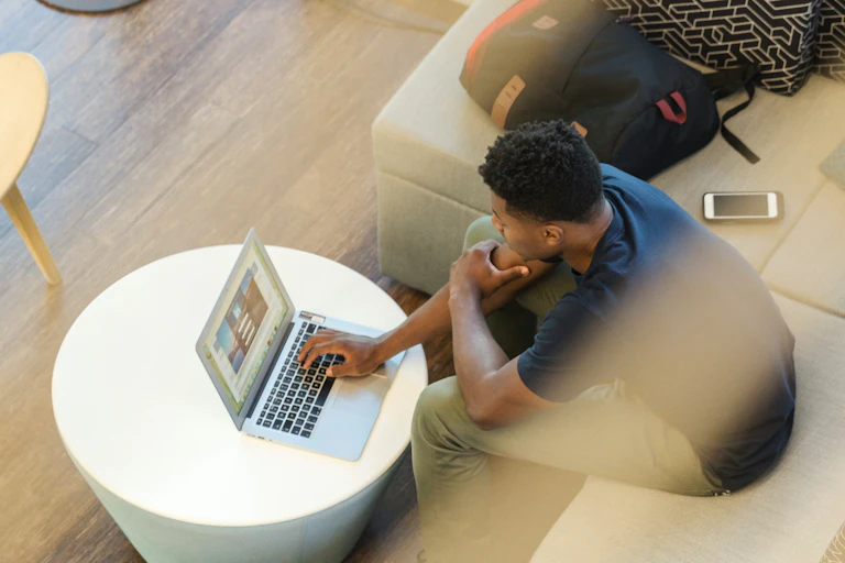 Man sitting on a sofa working at his laptop
