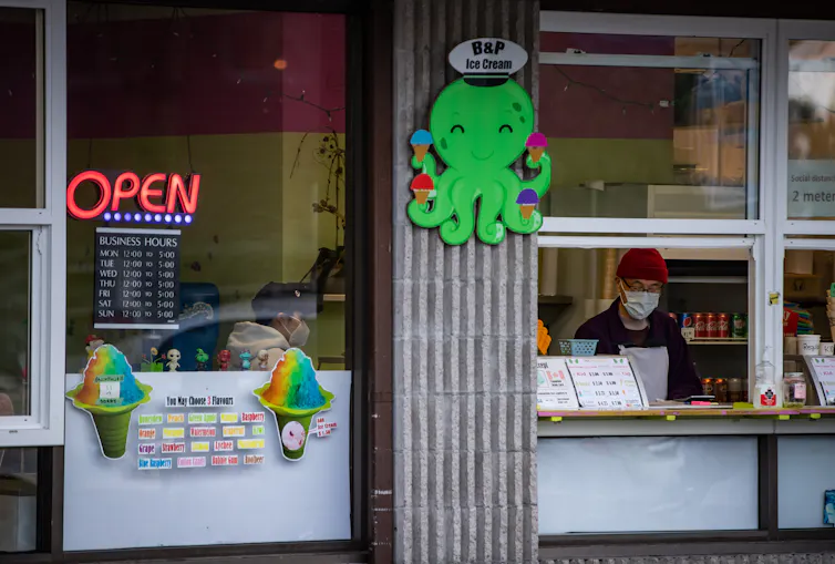 Workers at an ice cream shop wear face masks