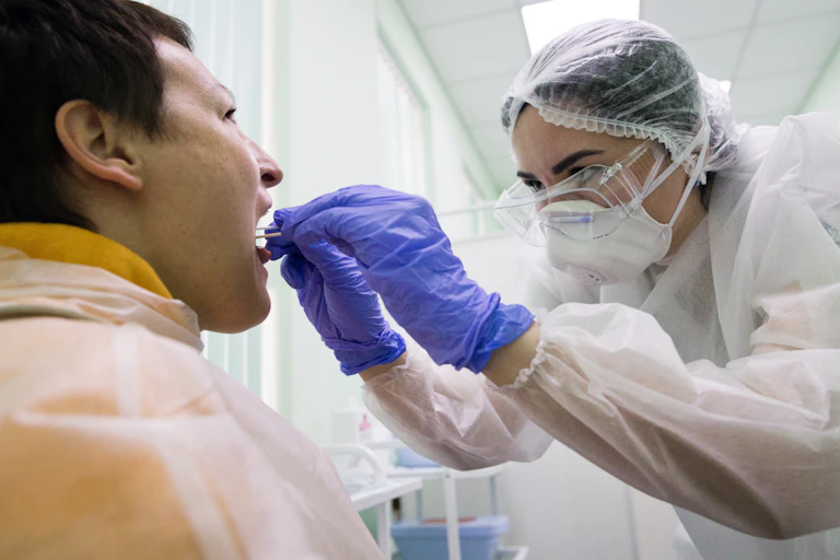 Medical worker takes a viral swab from a patient's mouth