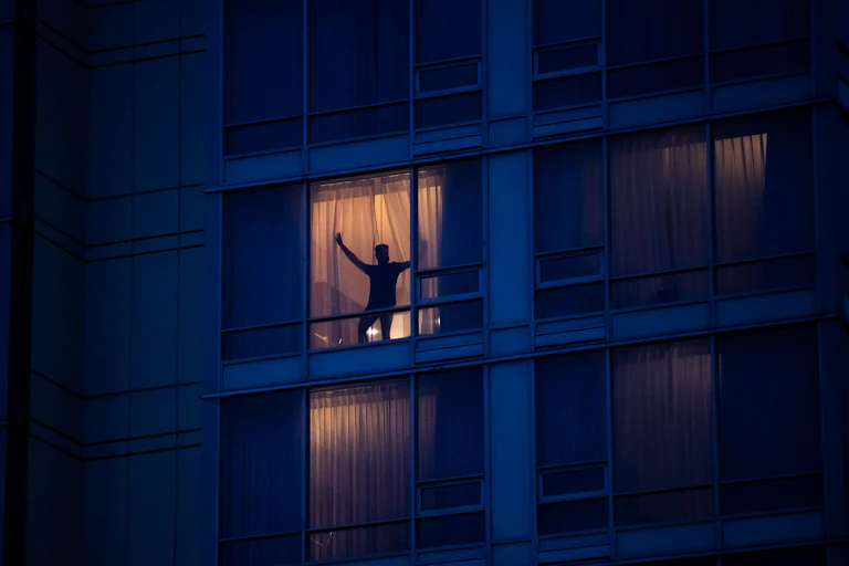 Man stands in window of hotel