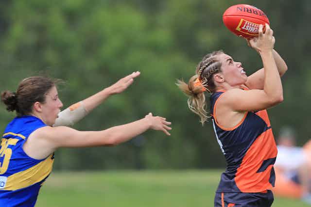 Jacinda Barclay takes a mark, with an opponent behind her.