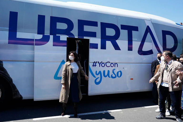 Isabel Díaz Yuso baja de un autobús con la palabra Libertad.
