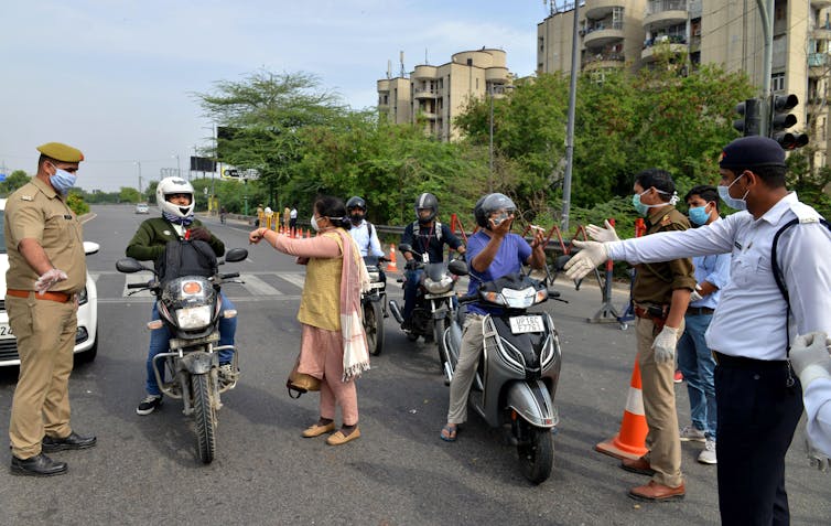 Police in India stopping commuters to ask why they are out during lockdown, New Delhi, India, March 24 2020.