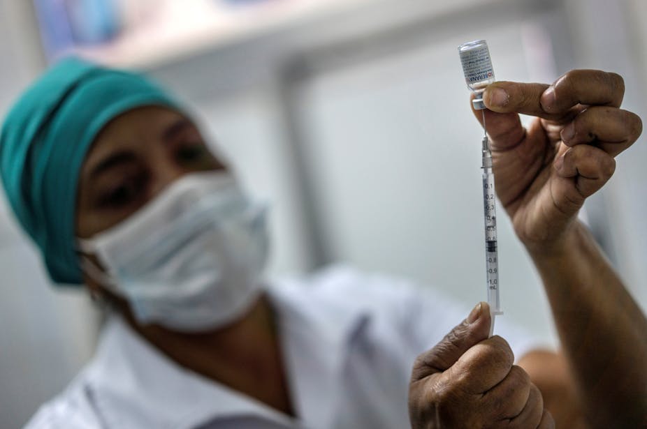 A nurse prepares an injection needle with Cuba's Soberana 2 vaccine.