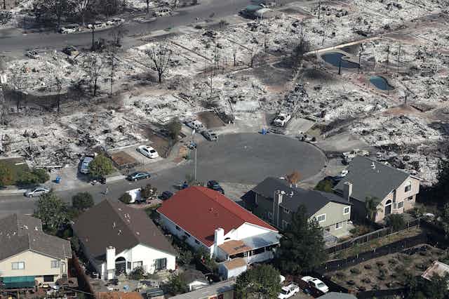 Five mostly untouched houses in a neighborhood burned to the ground