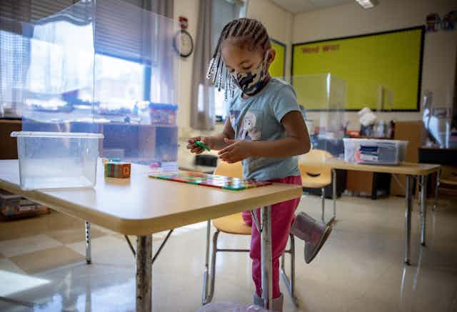 Preschool child works at a classroom desk