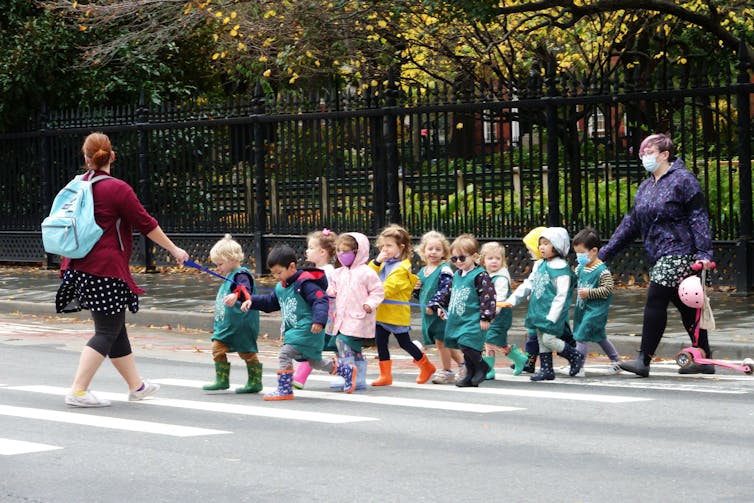 Line of pre-school students cross a street