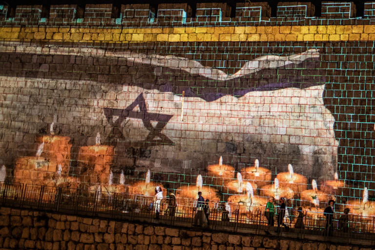 A condolence message and candles for the victims of a stampede during a Jewish ultra-Orthodox mass pilgrimage to Mount Meron is projected on a wall of Jerusalem's Old City.