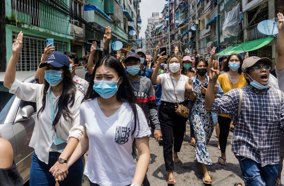 Burmese women wearing face masks march on the streets, wearing face masks